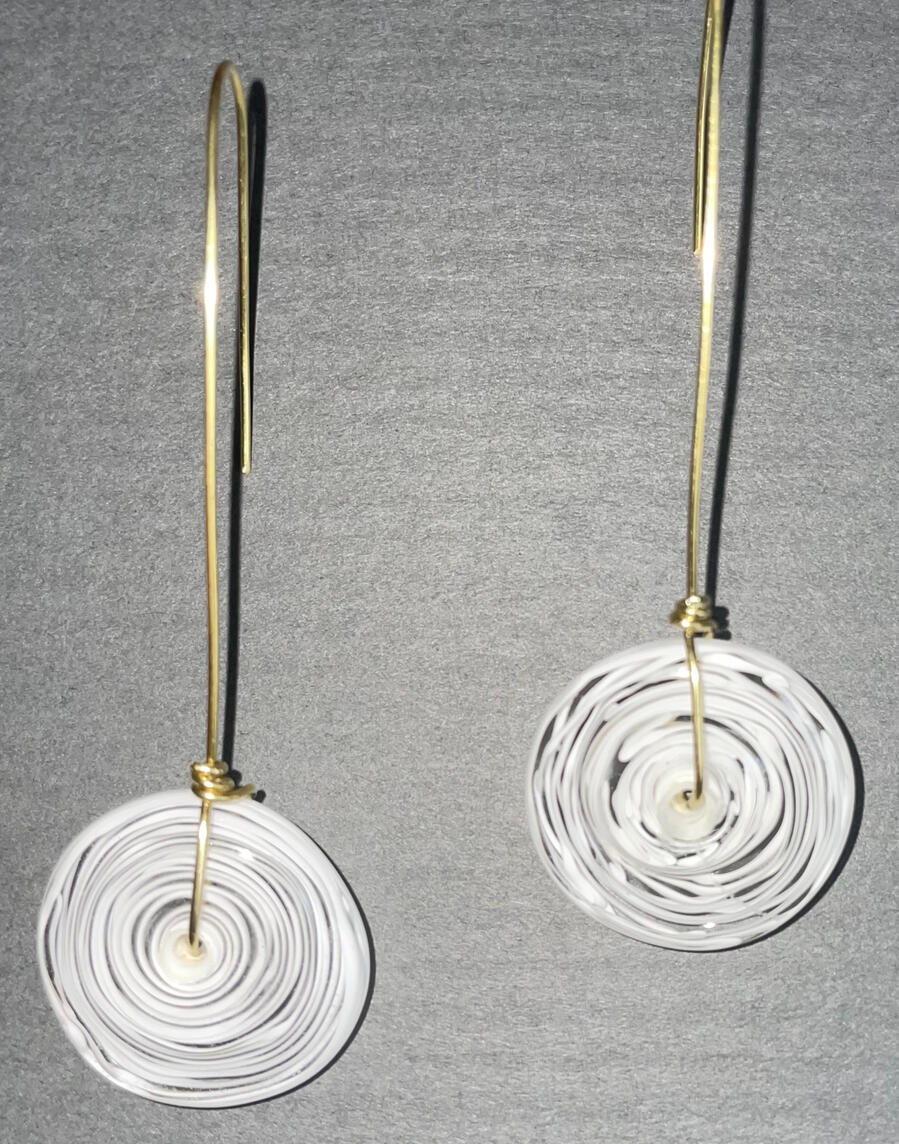 White disk on a brass wire